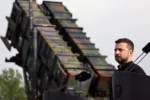 El presidente ucraniano, Volodymyr Zelensky, posa frente a un sistema de misiles de defensa aérea Patriot en Alemania, el 11 de junio de 2024. Créditos: Jens Butter, AFP.