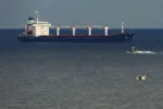 A boat with Russian, Ukrainian, Turkish and U.N. officials heads to the Sierra Leone-flagged cargo ship Razoni, to check if the grain shipment is in accordance with a crucial agreement signed last month by Moscow and Kyiv, at an inspection area in the Black Sea off the coast of Istanbul, Türkiye, Aug. 3, 2022. (AP Photo)