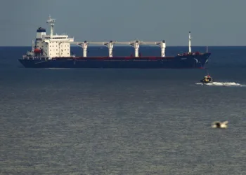 A boat with Russian, Ukrainian, Turkish and U.N. officials heads to the Sierra Leone-flagged cargo ship Razoni, to check if the grain shipment is in accordance with a crucial agreement signed last month by Moscow and Kyiv, at an inspection area in the Black Sea off the coast of Istanbul, Türkiye, Aug. 3, 2022. (AP Photo)