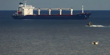 A boat with Russian, Ukrainian, Turkish and U.N. officials heads to the Sierra Leone-flagged cargo ship Razoni, to check if the grain shipment is in accordance with a crucial agreement signed last month by Moscow and Kyiv, at an inspection area in the Black Sea off the coast of Istanbul, Türkiye, Aug. 3, 2022. (AP Photo)