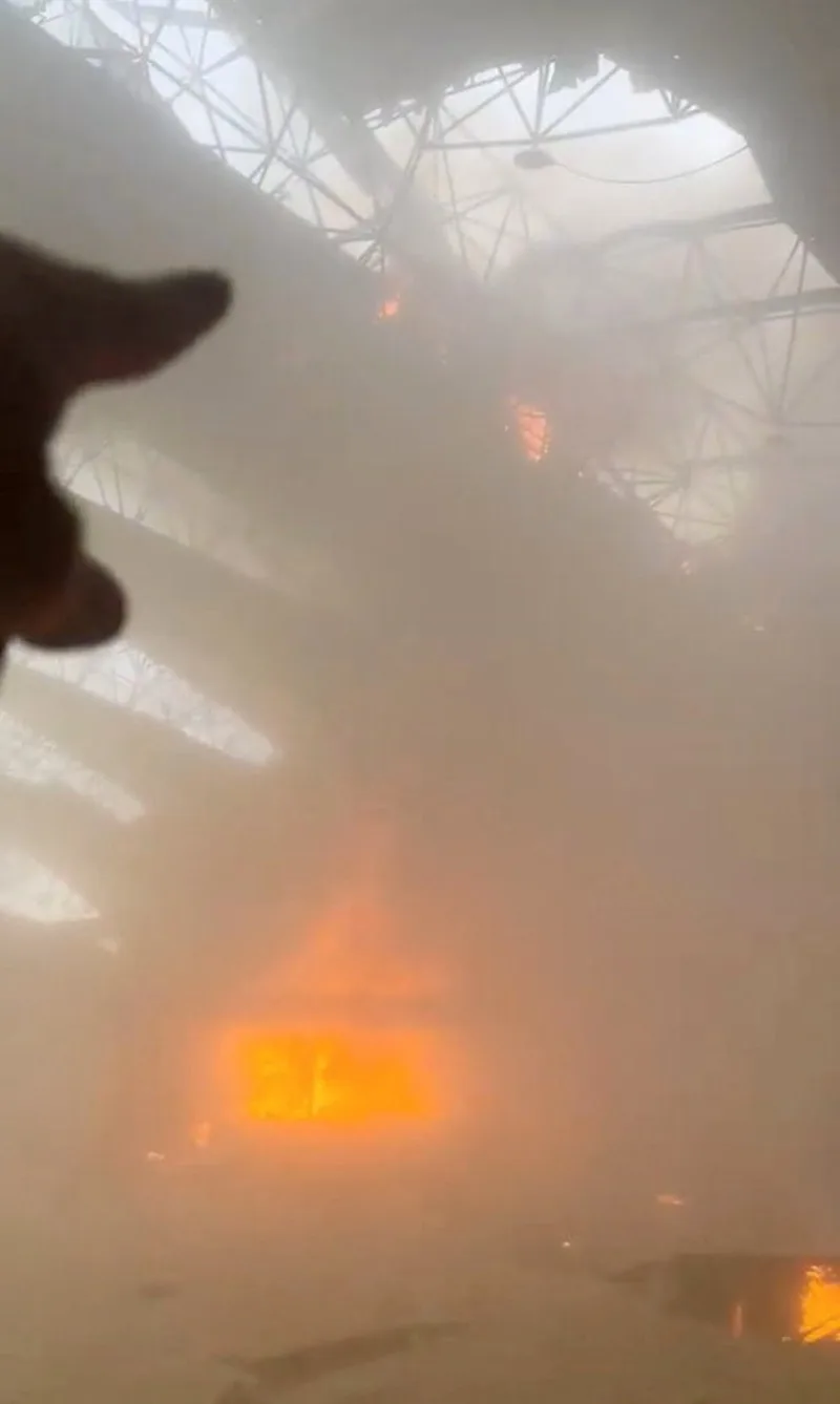 En el suelo yacen escombros mientras el fuego arde al fondo, tras los ataques iraníes, según el Ministerio de Asuntos Exteriores, en el Aeropuerto Internacional de Kuwait, en la ciudad de Kuwait (Kuwait), el 3 de junio de 2026, en esta imagen fija extraída de un vídeo de las redes sociales. Créditos: Redes sociales vía Reuters.