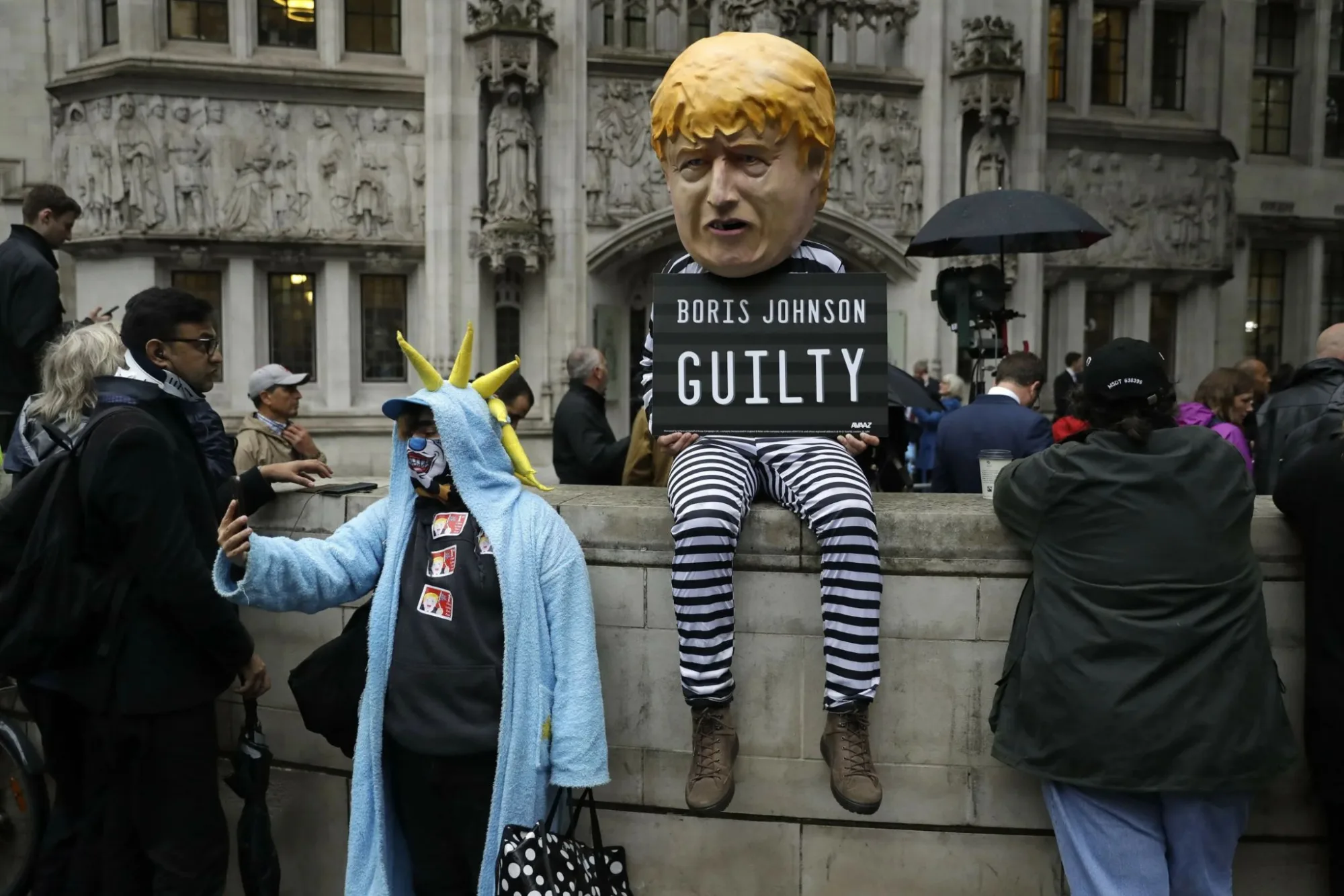 En esta foto de archivo del martes 24 de septiembre de 2019, una persona disfrazada de caricatura del primer ministro britanico Boris Johnson con uniforme de prision se encuentra frente a la Corte Suprema en Londres despues de que esta emitiera su decision sobre la legalidad de la suspension del Parlamento por cinco semanas decretada por Johnson. Créditos: AP.