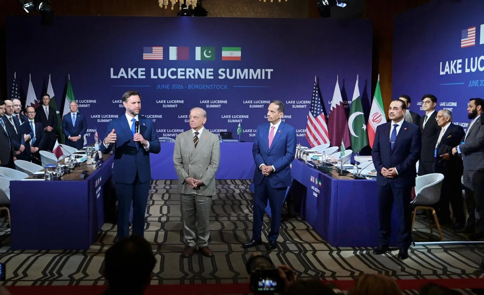 El vicepresidente de EE. UU., JD Vance, observa mientras el primer ministro de Pakistán, Shehbaz Sharif, toma la palabra de la mano del primer ministro y ministro de Asuntos Exteriores de Qatar, el jeque Mohammed bin Abdulrahman bin Jassim Al-Thani, al inicio de una reunión cuatripartita entre EE. UU., Irán, Pakistán y Qatar en la Cumbre del Lago de Lucerna, cuyo objetivo es impulsar un acuerdo para poner fin al conflicto de Oriente Medio, celebrada en el Buergenstock Resort del Lago de Lucerna, cerca de Stansstad (Suiza), el 21 de junio de 2026. Créditos: Shehbaz Sharif.