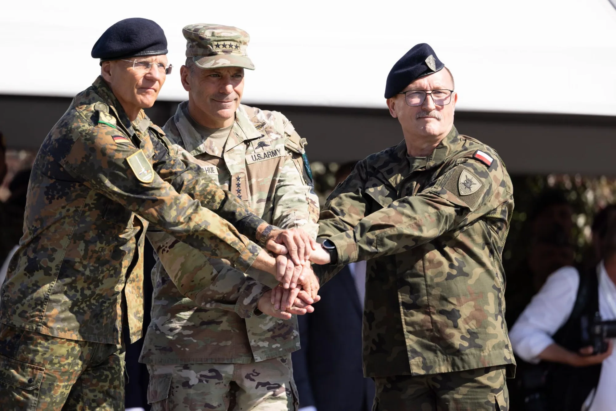 Generales Christopher Donahue (Comandante de Allied Land Command de la OTAN y del Ejército de EE.UU. en Europa), un alto mando alemán y el teniente general polaco Dariusz Parylak (Comandante del Multinational Corps Northeast) unen sus manos en un gesto simbólico durante la ceremonia de transferencia de mando táctico en Valga-Valka. Créditos: Ministerio de Defensa de Letonia.