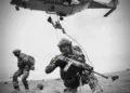 Soldados belgas equipados con armamento moderno y un helicóptero en operación. Créditos: Mando Terrestre Aliado de la OTAN.