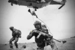 Soldados belgas equipados con armamento moderno y un helicóptero en operación. Créditos: Mando Terrestre Aliado de la OTAN.