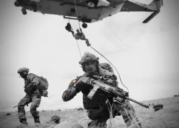Soldados belgas equipados con armamento moderno y un helicóptero en operación. Créditos: Mando Terrestre Aliado de la OTAN.