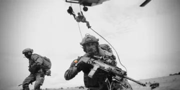 Soldados belgas equipados con armamento moderno y un helicóptero en operación. Créditos: Mando Terrestre Aliado de la OTAN.
