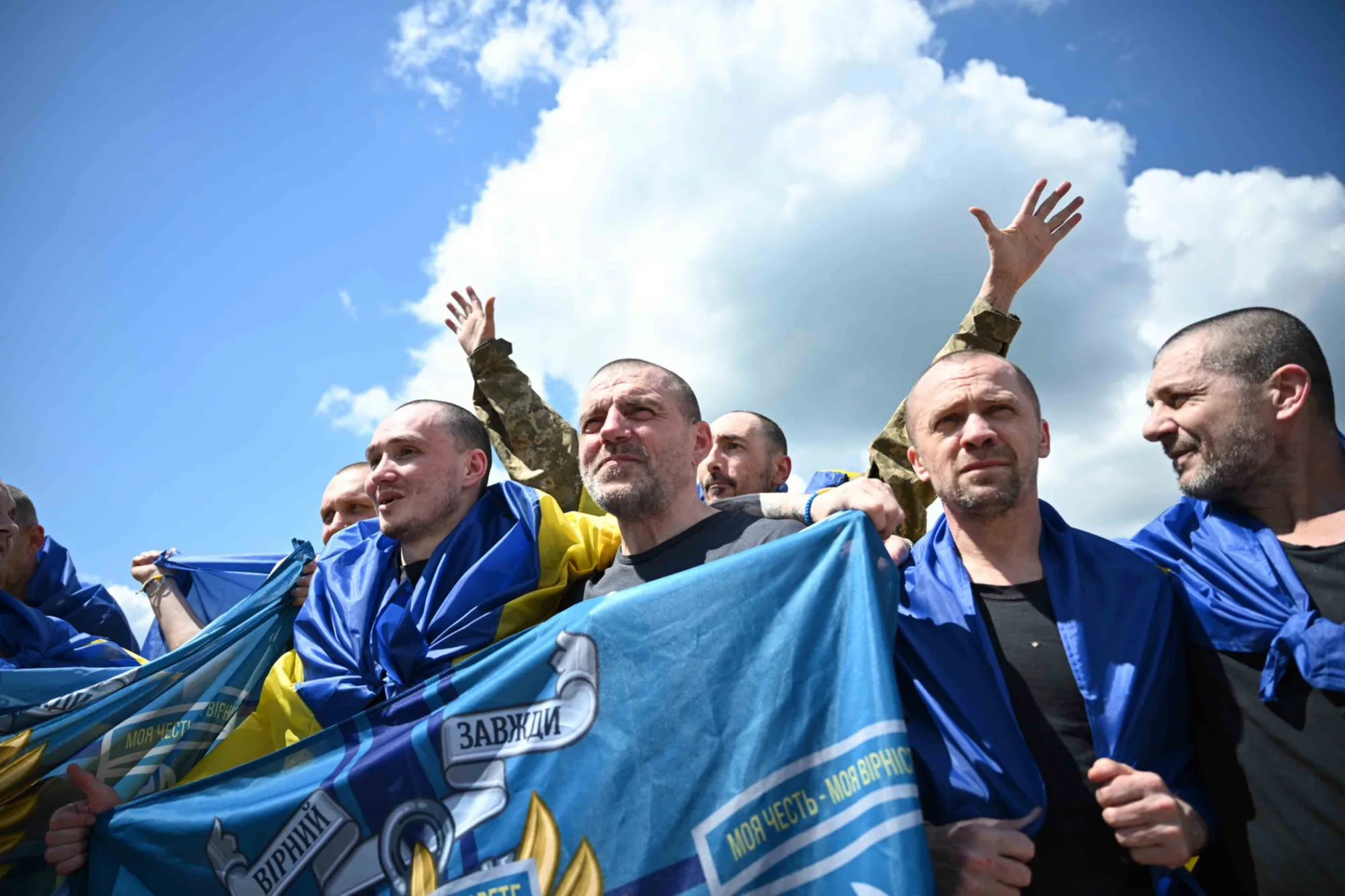 Soldados ucranianos recién liberados, envueltos en banderas nacionales. Créditos: Volodymyr Zelenskyy.
