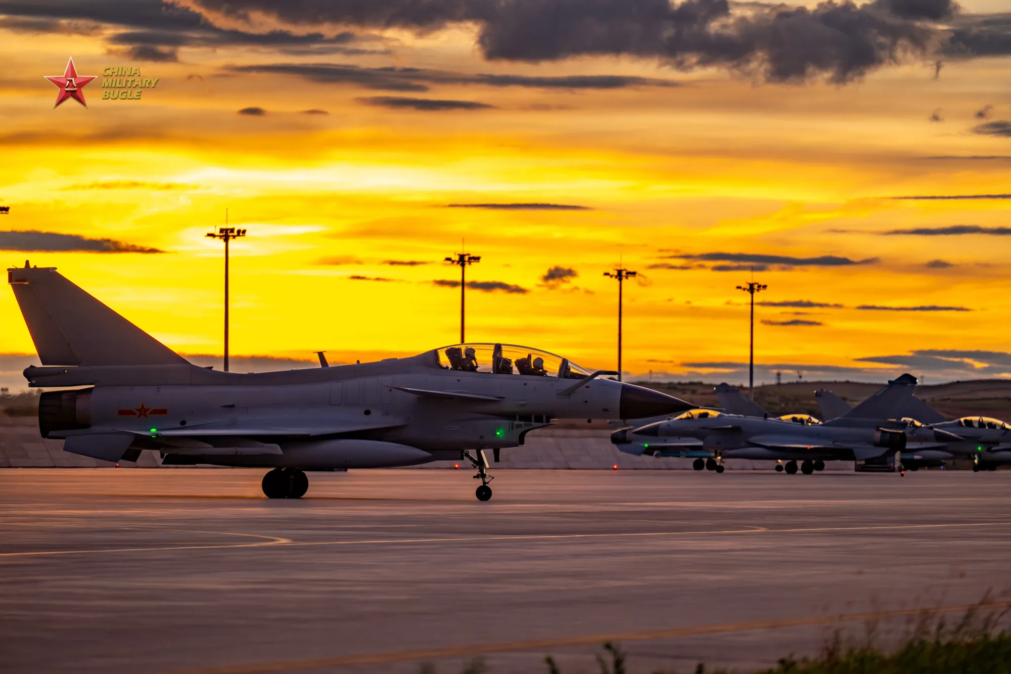 Varios cazas J-10 estacionados en la pista al atardecer, con pilotos visibles en las cabinas de la brigada de aviación de la Fuerza Aérea del Comando Sur del Ejército Popular de Liberación. Créditos: China Military Bugle.
