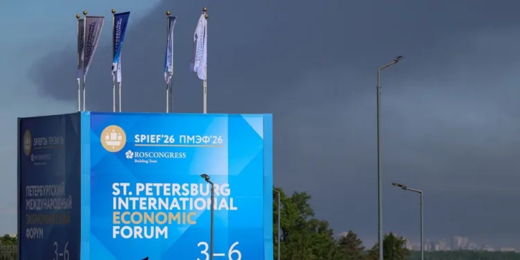 Agentes de policía se encuentran frente a un cartel y banderas con el logotipo del Foro Económico Internacional de San Petersburgo (SPIEF), mientras una densa humareda se eleva al fondo tras el impacto de drones en infraestructura, según informó el gobernador Alexander Beglov, en San Petersburgo, Rusia, el 3 de junio de 2026. REUTERS/Stringer
