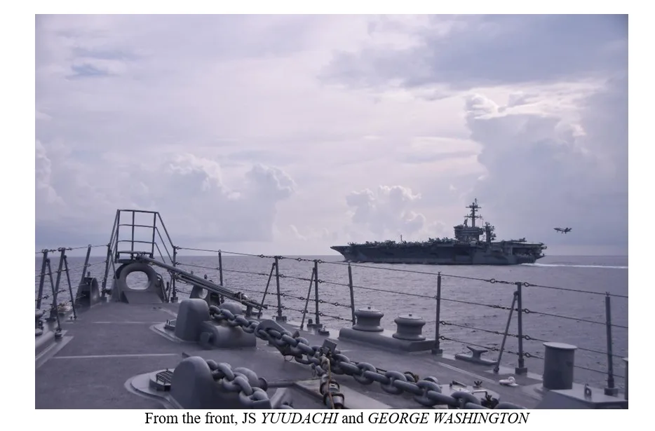 Vistas desde el JS YUUDACHI: Se muestran imágenes del destructor japonés en primer plano (incluyendo su armamento de cubierta y cadenas de anclaje) con el portaaviones USS GEORGE WASHINGTON navegando al fondo. Créditos: rensa de la Fuerza Marítima de Autodefensa de Japón (JMSDF).