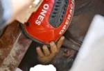 Héctor López se pone el casco que le han dado para protegerse la cabeza mientras varias personas intentan sacarlo de debajo de los escombros de un edificio derrumbado en La Guaira, Venezuela, el 25 de junio. Créditos: Reuters.