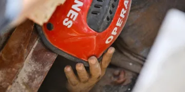 Héctor López se pone el casco que le han dado para protegerse la cabeza mientras varias personas intentan sacarlo de debajo de los escombros de un edificio derrumbado en La Guaira, Venezuela, el 25 de junio. Créditos: Reuters.