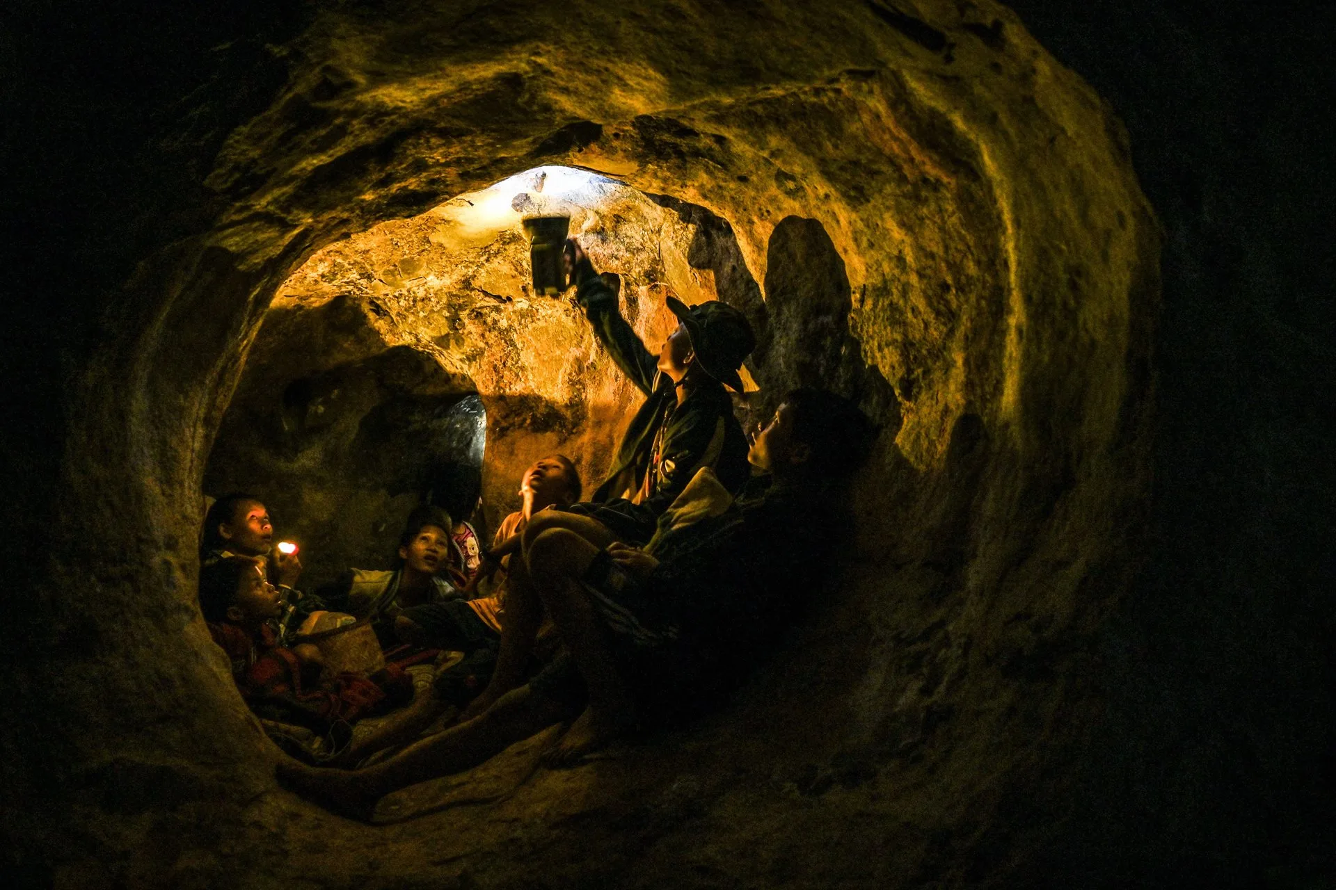 Unos civiles que se refugian en una cueva iluminan con una linterna a una araña, en Demoso, estado de Kayah (Karenni), Myanmar. Tras los ataques aéreos de la junta, tanto de día como de noche, durante esa semana, la gente no se atrevía a quedarse en casa y optaba por dormir en cuevas. Según un informe de las Naciones Unidas, unos 5.000 civiles han perdido la vida desde el golpe de Estado de 2021. Créditos: Ye Aung Thu.