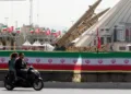 Una pareja iraní pasa en motocicleta frente a misiles iraníes, Zolfaghar, exhibidos en la Plaza Azadi en Teherán. Fotografía: Abedin Taherkenareh/EPA