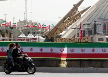 Una pareja iraní pasa en motocicleta frente a misiles iraníes, Zolfaghar, exhibidos en la Plaza Azadi en Teherán. Fotografía: Abedin Taherkenareh/EPA