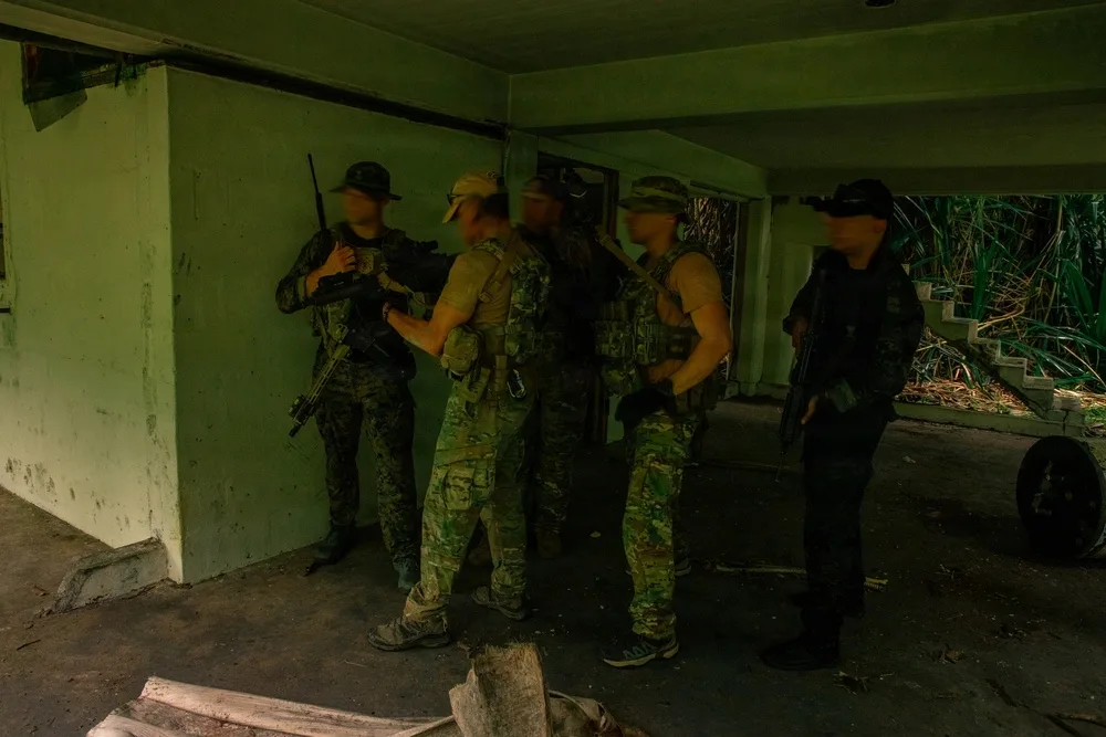 El Comando de Operaciones Especiales del Cuerpo de Marines de EE. UU. (MARSOC) junto a un miembro de las fuerzas especiales argentinas y un miembro del Grupo de Apoyo Operacional (GAO) del Servicio de Protección Institucional de Panamá en el simulacro de asalto a un edificio durante la fase de Entrenamiento de Integración de Fuerzas (FIT) de PANAMAX 2026 en la provincia de Colón, Panamá, el 2 de agosto de 2026. Créditos: Ejército de EE. UU.