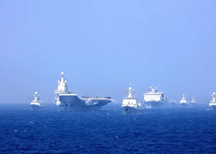 Un grupo de combate naval liderado por el portaaviones chino Liaoning (16) navega en formación durante unas maniobras militares en el Mar de China Meridional