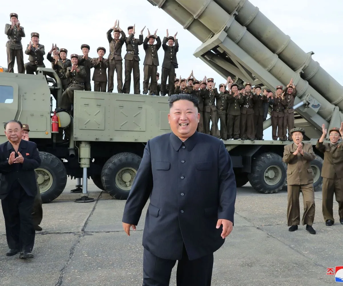 Kim Jong-un, líder de Corea del Norte, posa junto a un sistema de misiles mientras soldados celebran durante una demostración de fuerza del país