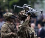 Un soldado sostiene un dron equipado con cámaras durante una demostración de tecnología militar. Imagen ilustrativa