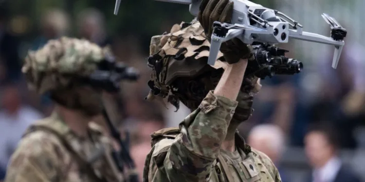 Un soldado sostiene un dron equipado con cámaras durante una demostración de tecnología militar. Imagen ilustrativa