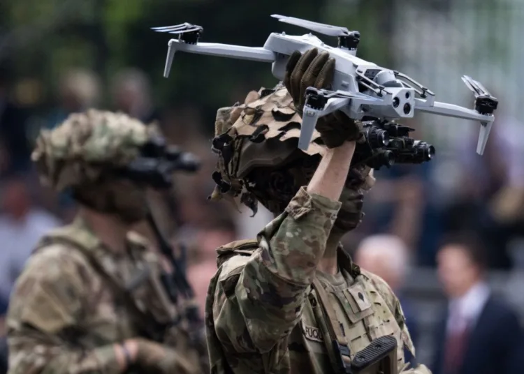Un soldado sostiene un dron equipado con cámaras durante una demostración de tecnología militar. Imagen ilustrativa