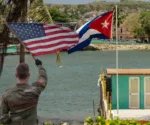 Un soldado estadounidense con la bandera de su país frente a Cuba. Fotomontaje con Stock en Canva. Imagen ilustrativa