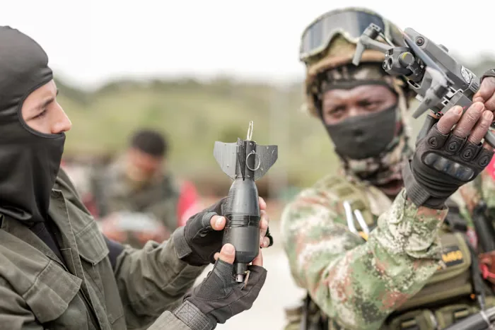 Guerrilleros colombianos practican cómo acoplar una granada a un dron. Créditos: Alex Kemman.