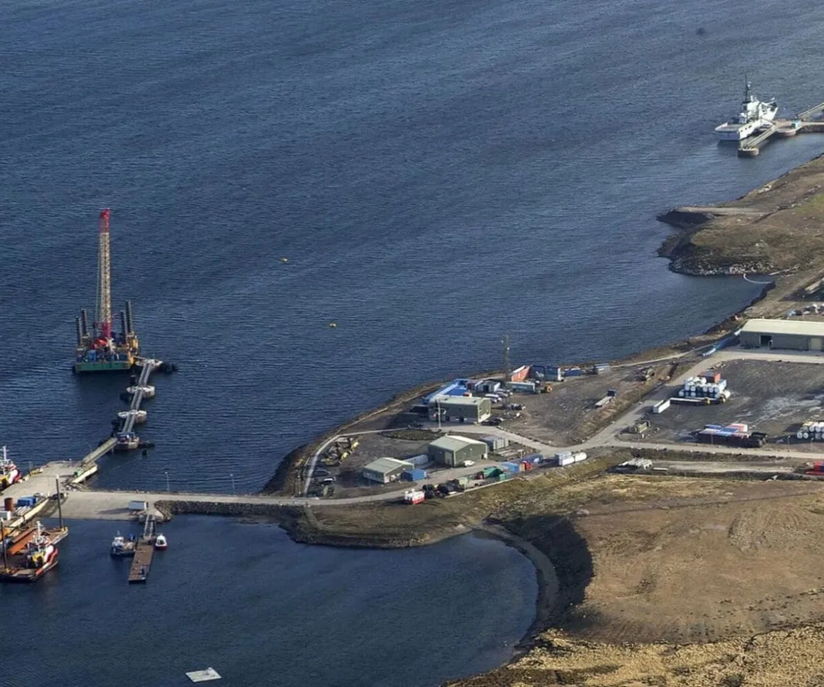 Vista aérea de instalaciones portuarias e infraestructura logística en las Islas Malvinas –bajo administración británica– sobre la costa de una bahía