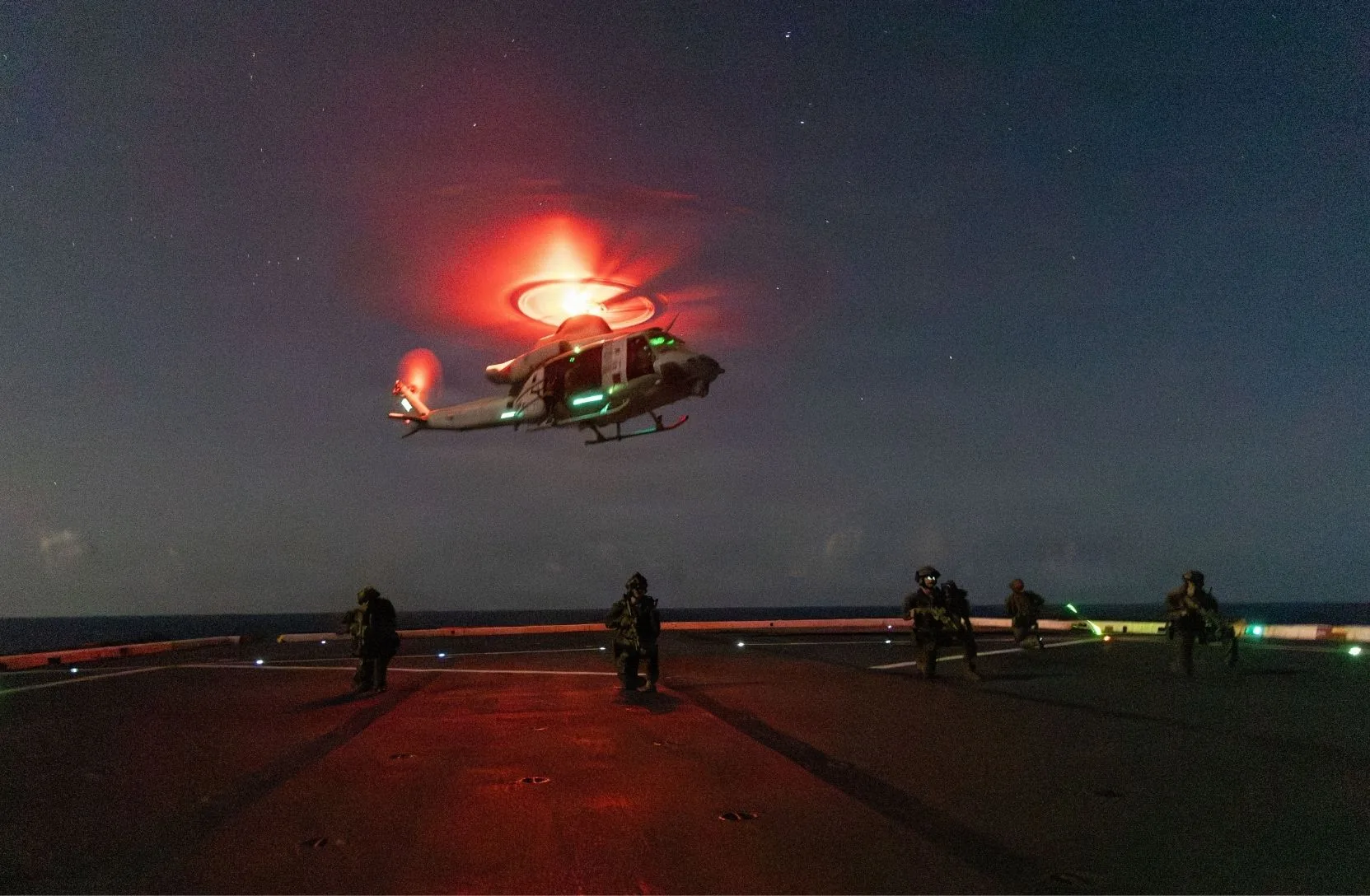 Infantes de Marina de EE. UU. con la Fuerza de Combate Litoral-24 y guardacostas estadounidenses con el Equipo de Aplicación de la Ley Táctica del Pacífico realizan ejercicios de descenso rápido con poca luz en la cubierta de vuelo del USS San Antonio (LPD 17) desde un UH-1Y Venom del Cuerpo de Infantería de Marina de EE. UU. en el Mar Caribe, 23 de julio de 2026. Crédito: Southcom