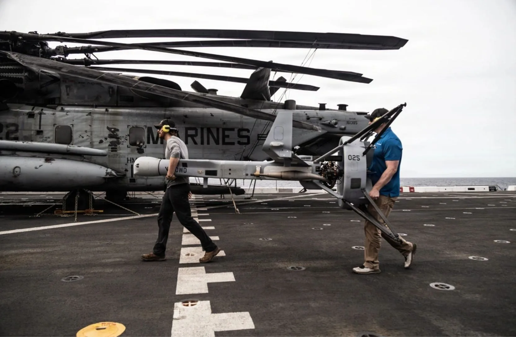 Contratistas que prestan apoyo a la 11.ª Unidad Expedicionaria de la Infantería de Marina, de la 1.ª Fuerza Expedicionaria de la Infantería de Marina, transportan un sistema aéreo no tripulado V-BAT a bordo del buque de transporte anfibio de la clase San Antonio USS Portland (LPD 27) en el Océano Pacífico (Foto del Cuerpo de Marines de EE. UU. tomada por el cabo Luke Rodríguez)