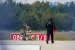 Un agente de policía con equipo de protección camina junto a un robot de desactivación de explosivos (EOD) en el aeropuerto de Leipzig/Halle, en Schkeuditz (Alemania), el 5 de agosto de 2026. Créditos. Axel Schmidt