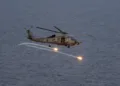 Un helicóptero MH-60R Seahawk lanza bengalas durante un ejercicio de coordinación de ataques y reconocimiento mientras opera en el Mar de China Meridional, el 12 de agosto de 2026. Créditos: Armada de EE. UU.