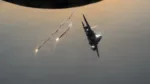 Un avión F-15E Strike Eagle de la Fuerza Aérea de EE. UU. despliega bengalas tras repostar desde un avión KC-135 Stratotanker de la Fuerza Aérea de EE. UU. en el área de responsabilidad del Mando Central de EE. UU. el 19 de agosto de 2026. (Foto de la Fuerza Aérea de EE. UU. por el Sargento Mayor James K. Thomas)