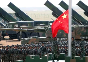 Soldados del Ejército Popular de Liberación (EPL) de China rinden honores militares, durante el izado de la bandera nacional en una base de entrenamiento