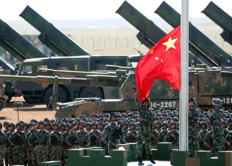 Soldados del Ejército Popular de Liberación (EPL) de China rinden honores militares, durante el izado de la bandera nacional en una base de entrenamiento