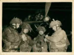 Soldados británicos de la 6º División Aerotransportada sincronizando sus relojes frente a un avión antes del salto en Normandía en 1944. Créditos: Ejército Británico.