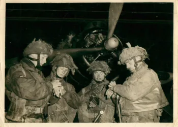 Soldados británicos de la 6º División Aerotransportada sincronizando sus relojes frente a un avión antes del salto en Normandía en 1944. Créditos: Ejército Británico.