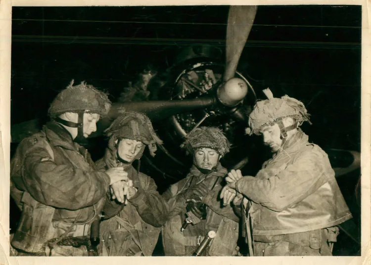 Soldados británicos de la 6º División Aerotransportada sincronizando sus relojes frente a un avión antes del salto en Normandía en 1944. Créditos: Ejército Británico.
