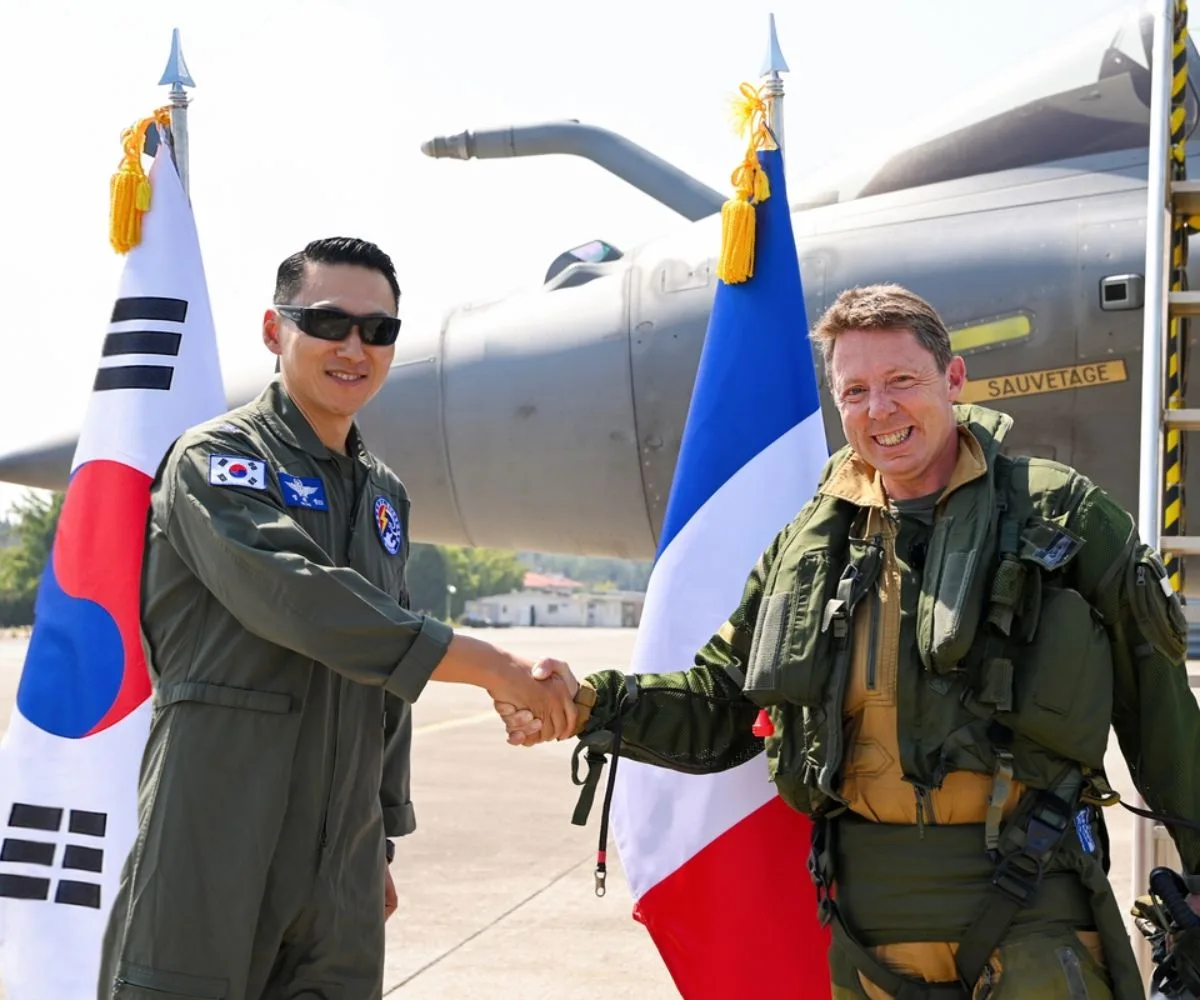 Aviadores surcoreanos y franceses dándose la mano tras su llegada a una base aérea en Cheongju, a unos 110 kilómetros al sur de Seúl, el 15 de septiembre de 2026.