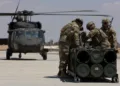 Soldados estadounidenses, adscritos a la Fuerza de Tarea Hurricane y a la Fuerza de Tarea Sentinel, se preparan para fijar un módulo de sistema de lanzamiento múltiple de cohetes guiados a un helicóptero UH-60A Blackhawk durante un entrenamiento en el marco del ejercicio Eager Lion 2024 en la Base Aérea Muwaffaq Salti. Crédito: Ejército de EE.UU.