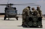 Soldados estadounidenses, adscritos a la Fuerza de Tarea Hurricane y a la Fuerza de Tarea Sentinel, se preparan para fijar un módulo de sistema de lanzamiento múltiple de cohetes guiados a un helicóptero UH-60A Blackhawk durante un entrenamiento en el marco del ejercicio Eager Lion 2024 en la Base Aérea Muwaffaq Salti. Crédito: Ejército de EE.UU.