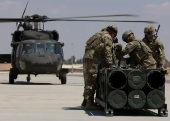 Soldados estadounidenses, adscritos a la Fuerza de Tarea Hurricane y a la Fuerza de Tarea Sentinel, se preparan para fijar un módulo de sistema de lanzamiento múltiple de cohetes guiados a un helicóptero UH-60A Blackhawk durante un entrenamiento en el marco del ejercicio Eager Lion 2024 en la Base Aérea Muwaffaq Salti. Crédito: Ejército de EE.UU.