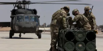 Soldados estadounidenses, adscritos a la Fuerza de Tarea Hurricane y a la Fuerza de Tarea Sentinel, se preparan para fijar un módulo de sistema de lanzamiento múltiple de cohetes guiados a un helicóptero UH-60A Blackhawk durante un entrenamiento en el marco del ejercicio Eager Lion 2024 en la Base Aérea Muwaffaq Salti. Crédito: Ejército de EE.UU.