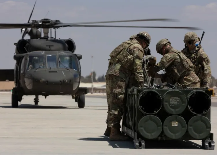 Soldados estadounidenses, adscritos a la Fuerza de Tarea Hurricane y a la Fuerza de Tarea Sentinel, se preparan para fijar un módulo de sistema de lanzamiento múltiple de cohetes guiados a un helicóptero UH-60A Blackhawk durante un entrenamiento en el marco del ejercicio Eager Lion 2024 en la Base Aérea Muwaffaq Salti. Crédito: Ejército de EE.UU.