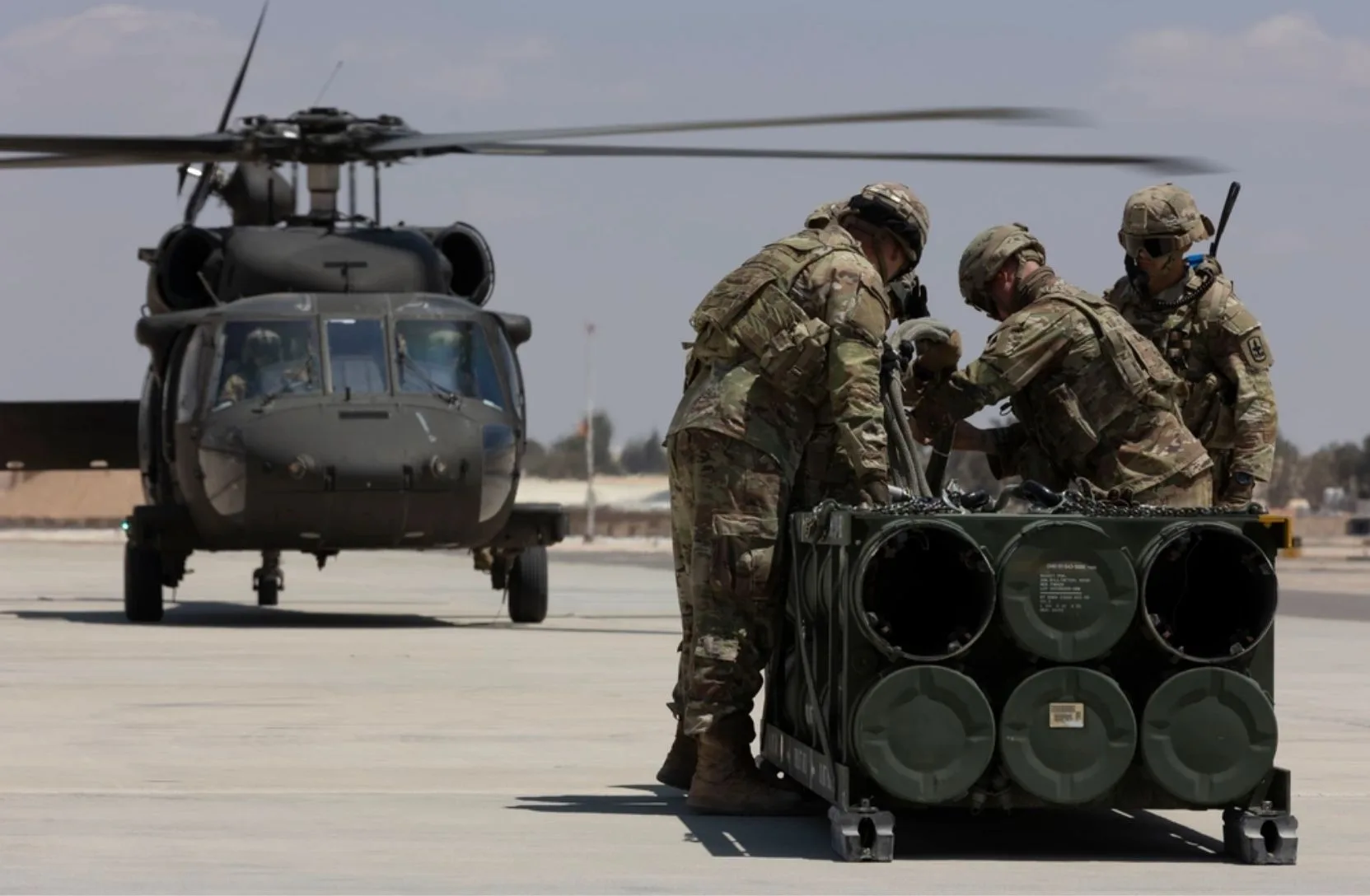 Soldados estadounidenses, adscritos a la Fuerza de Tarea Hurricane y a la Fuerza de Tarea Sentinel, se preparan para fijar un módulo de sistema de lanzamiento múltiple de cohetes guiados a un helicóptero UH-60A Blackhawk durante un entrenamiento en el marco del ejercicio Eager Lion 2024 en la Base Aérea Muwaffaq Salti. Crédito: Ejército de EE.UU.