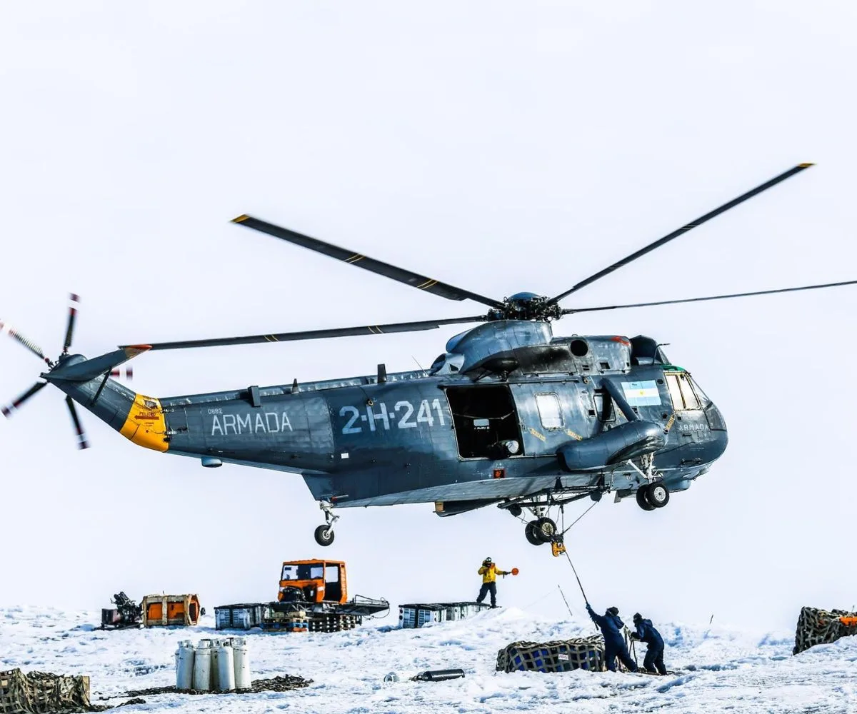 Un helicóptero Sikorsky SH-3H Sea King (matrícula 2-H-241), perteneciente a la Segunda Escuadrilla Aeronaval de Helicópteros de la Armada Argentina, realiza maniobras de carga externa para transportar suministros e insumos esenciales hacia una base argentina en la Antártida