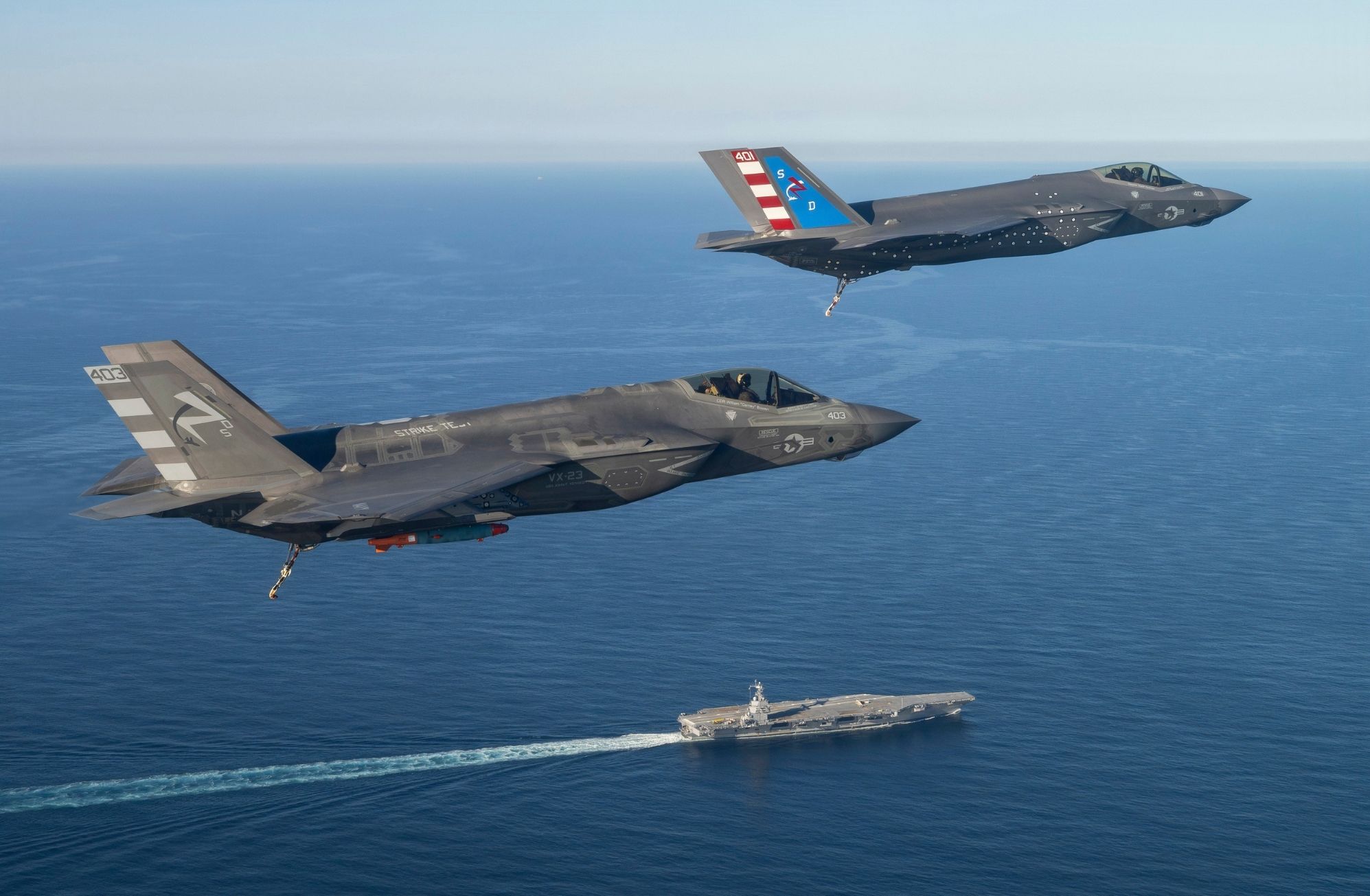 Dos pilotos de pruebas de F-35 del Escuadrón de Pruebas y Evaluación Aérea Dos Tres (VX-23), División de Aeronaves del Centro de Guerra Aérea Naval (NAWCAD), vuelan aviones de combate F-35C Lightning II hacia la PCU John F. Kennedy (CVN 79) en el Atlántico Occidental el 13 de octubre de 2026