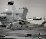 Un helicóptero AgustaWestland Merlin HM2 del Escuadrón Aéreo Naval 820 de la Royal Navy sobrevuela el portaaviones HMS Queen Elizabeth (R08) durante las pruebas de mar frente a la costa de Escocia, el 26 de junio de 2017. Imagen ilustrativa
